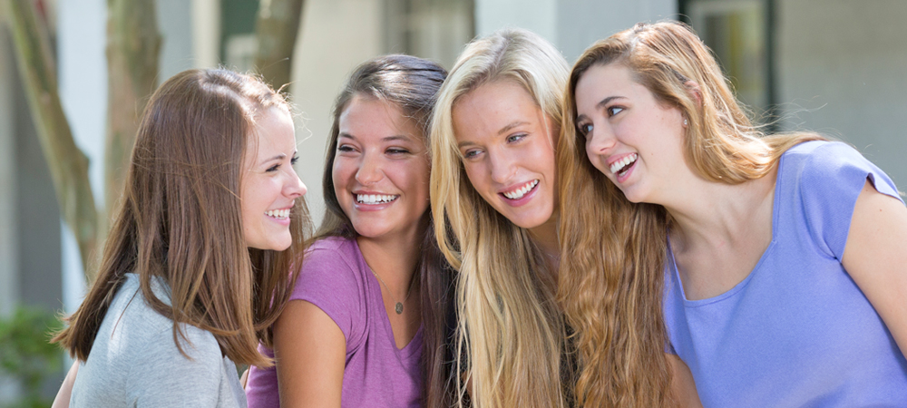 4 female friends smiling