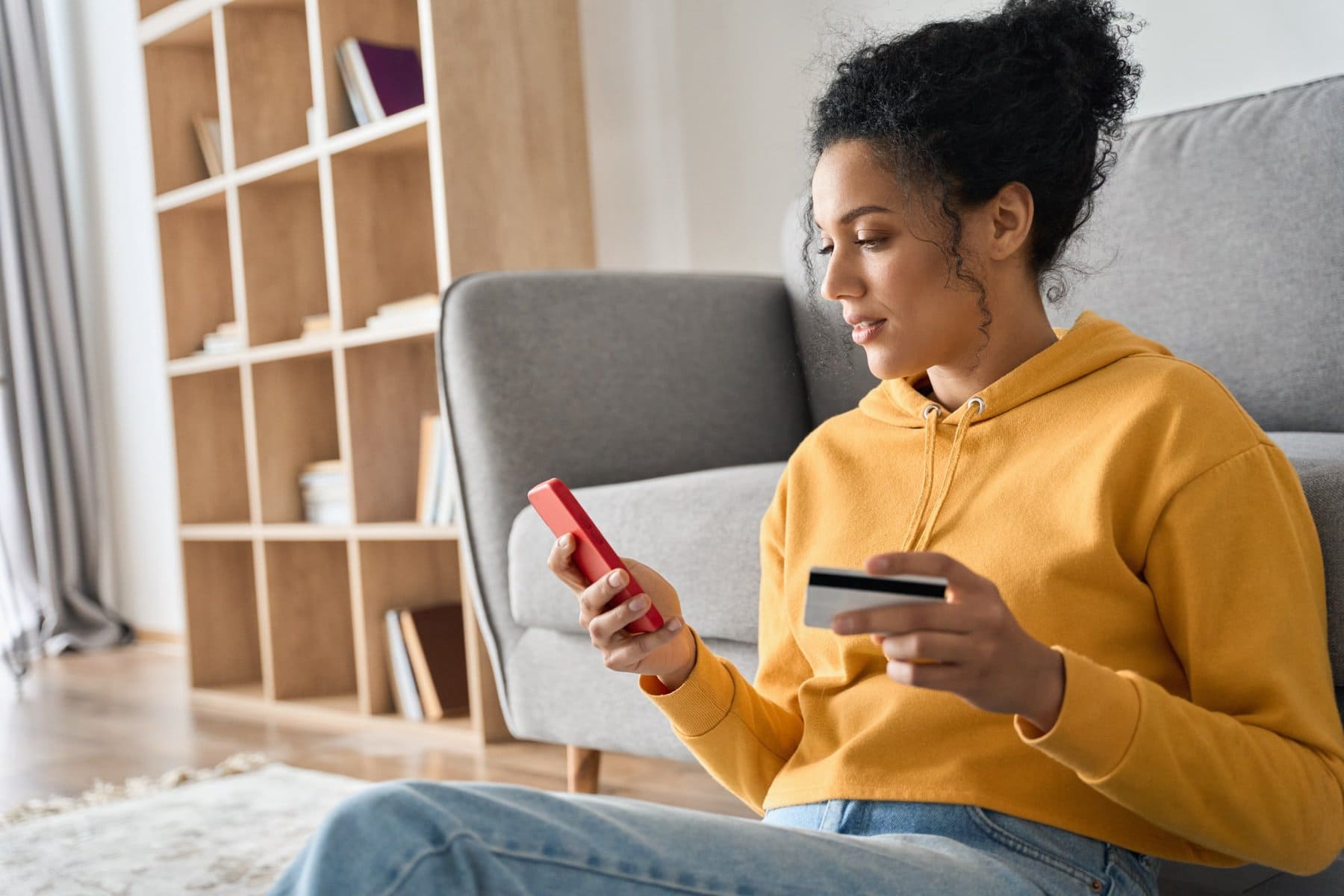 woman yellow on phone with card