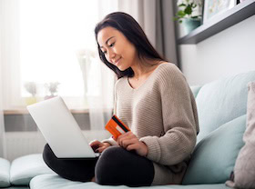 woman sitting on bed card computer