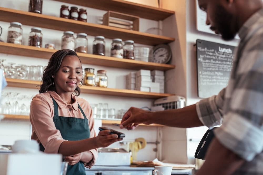 A barista is taking payment from a customer