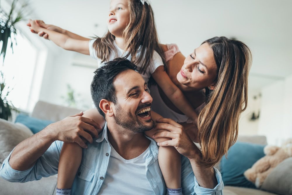 a family consisting of a mom, dad, and daughter playing