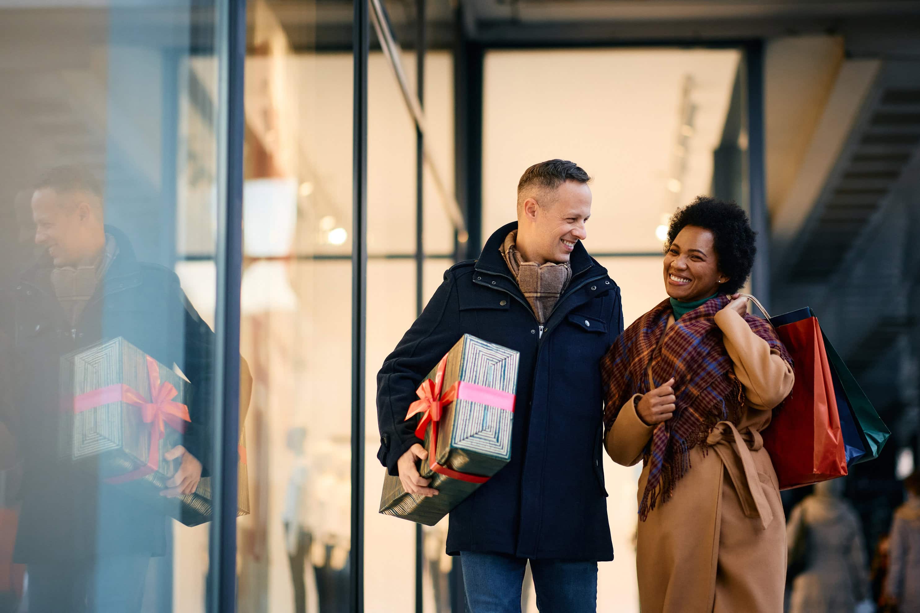 Happy couple enjoying in shopping for Christmas in city.